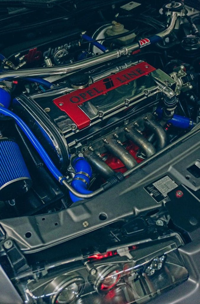 Close-up of a customized Opel engine featuring chrome and blue details, ideal for automotive enthusiasts.